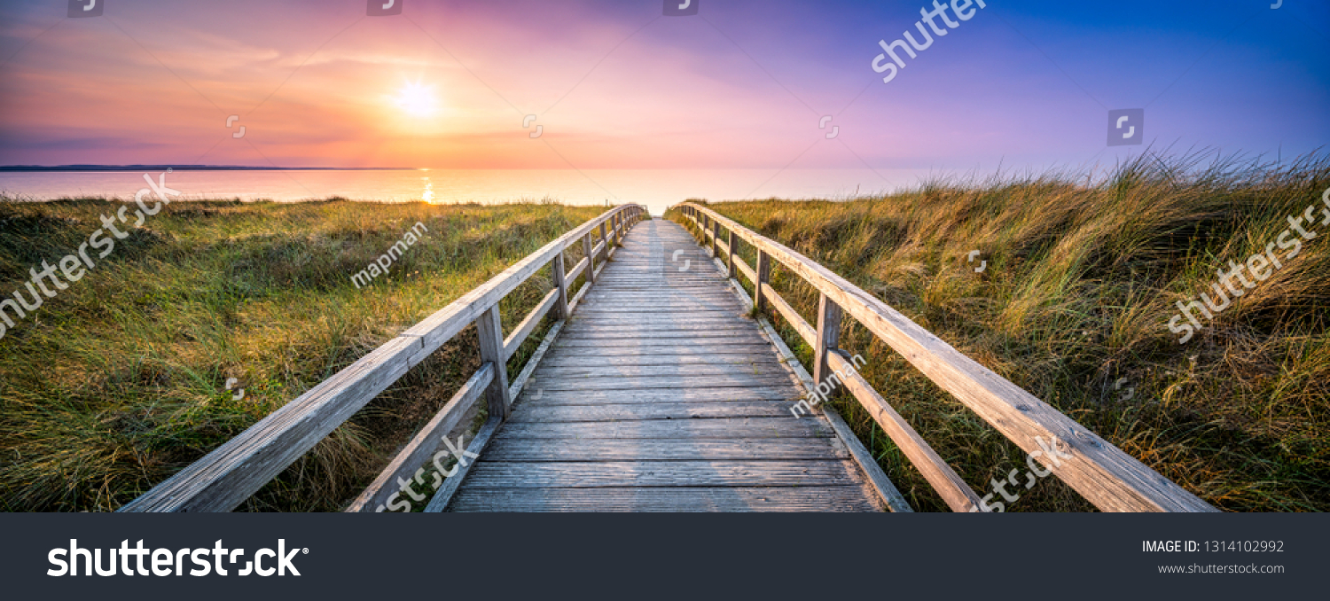 Holzsteg an den Dünen bei Sonnenuntergang