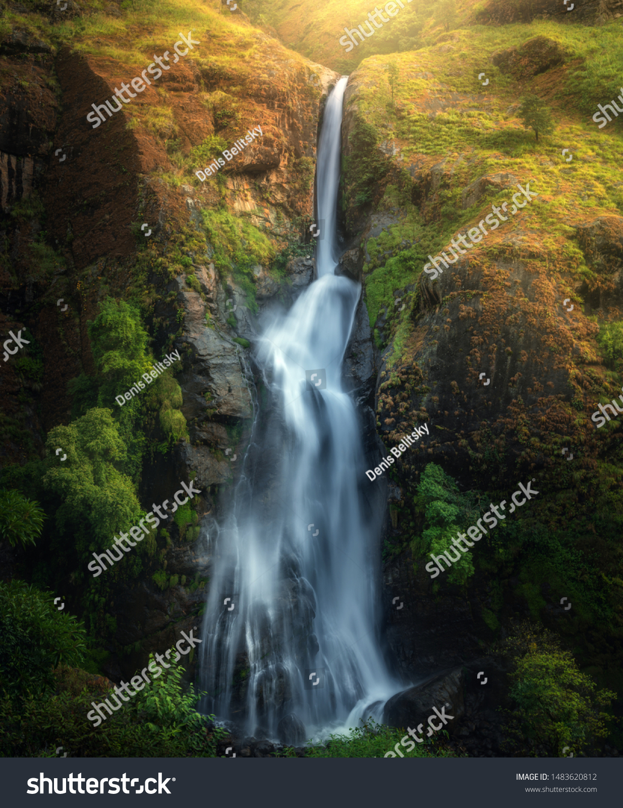 Wasserfall im herbstlichen Wald bei Sonnenuntergang